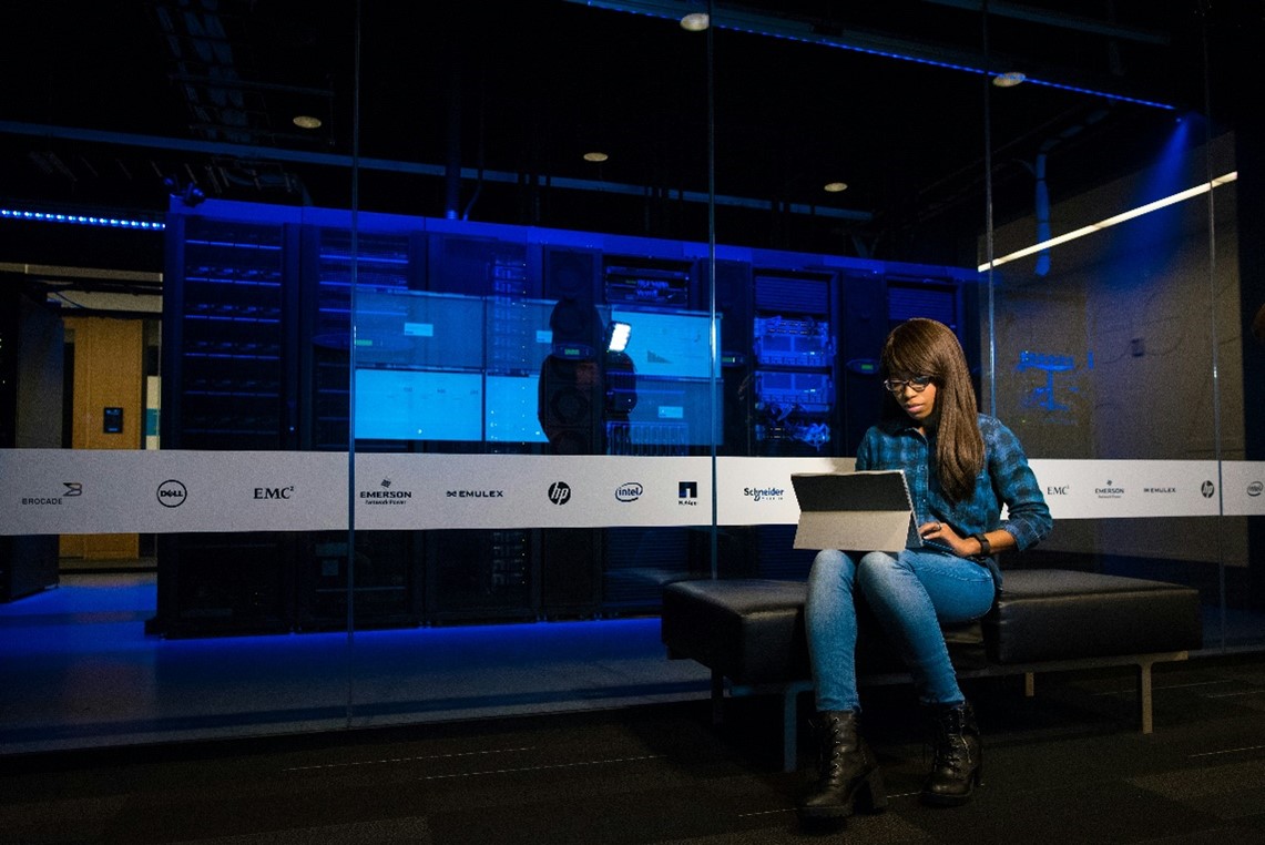 Women on laptop infront of glass wall